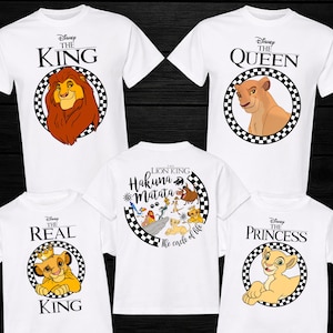 Op de afbeelding: Witte T-shirts met ontwerpen van The Lion King. De shirts tonen "The King" met een leeuw, "The Queen" met een leeuwin, "The Real King" met een welp, "The Princess" met een welp, en een shirt met "Hakuna Matata".