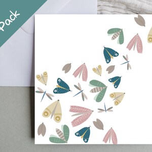 May include: A pack of ten square cards with a white background, featuring a whimsical design of colourful moths and dragonflies. The moths are in shades of blue, pink, green, and yellow. The text "10 Pack" is in the upper left corner.
