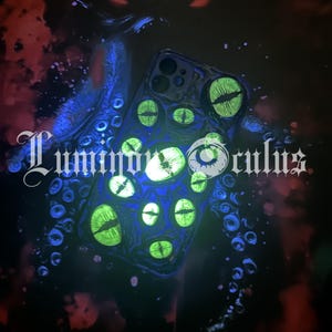 May include: A glowing phone case with a design of multiple green glowing eyes. The case is black with blue and red accents, and the text "Glowing in the dark" and "Luminfor Oculus" are visible.