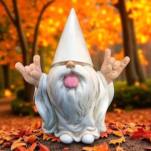May include: A whimsical garden gnome statue with a white pointed hat and beard, making a rock-and-roll hand gesture. The gnome has a pink tongue sticking out. The statue is set against a blurred background of fall foliage.