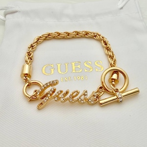 Könnte beinhalten: Ein Set aus drei Keramikbechern mit gesprenkelter, matter Oberfläche. Die Becher sind in Creme-, Hellgrau- und Dunkelgrautönen gehalten. Jeder Becher hat ein schlichtes, minimalistisches Design und einen abgerundeten Henkel.