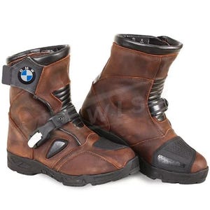 Pode incluir: Par de botas de motociclismo em couro castanho com detalhes em preto. As botas apresentam um logótipo BMW, fecho de fivela e sola texturizada. Projetadas para proteção e durabilidade.