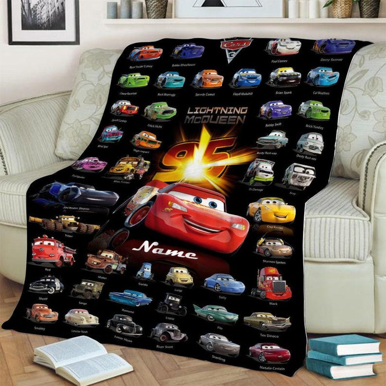 May include: A black fleece blanket featuring a large red Lightning McQueen character from the movie Cars, surrounded by numerous smaller colorful car characters. The text Lightning McQueen and the number 95 are printed in the center with Name below.