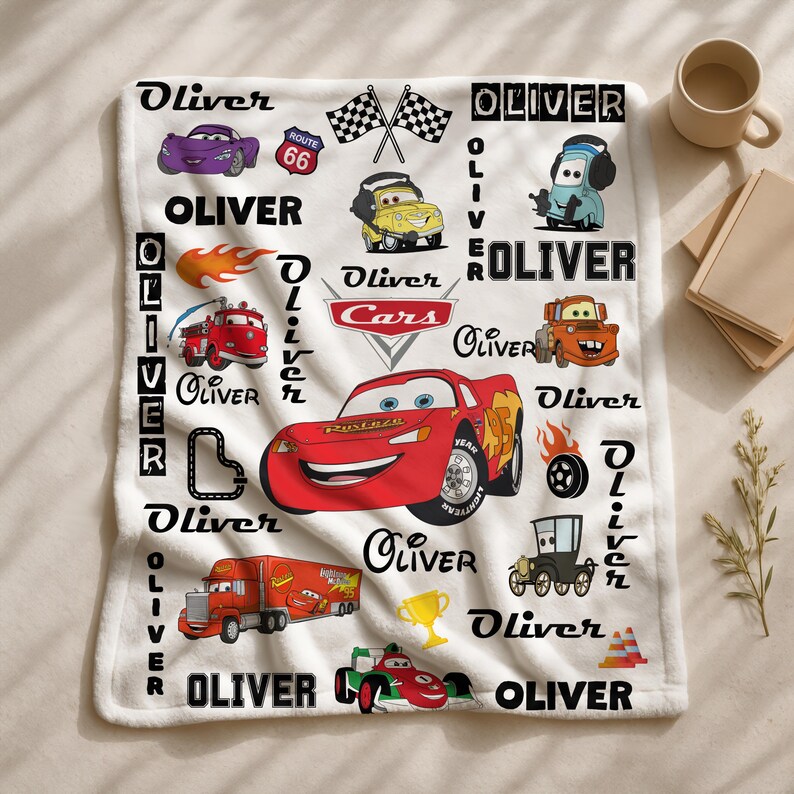 May include: A white fleece blanket featuring a repeating pattern of characters and icons from the movie Cars, including Lightning McQueen, Mater, and a red semi-truck. The name Oliver is printed in various fonts throughout the design alongside checkered flags, a Route 66 sign, flames, and a gold trophy.