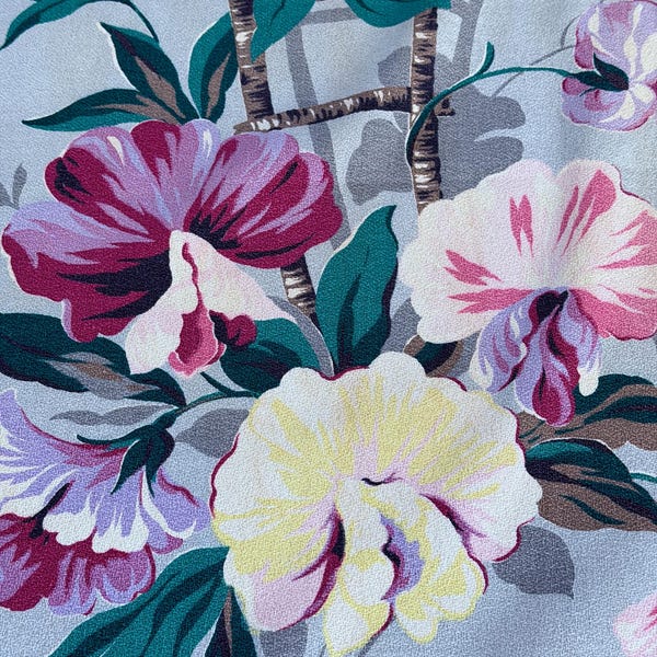 Cortina de tela vintage estilo art déco de los años 30 con orquídeas lilas y mandevills.