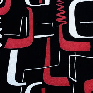 Puede incluir: Tela de patrón geométrico abstracto en negro, blanco y rojo. El patrón presenta un diseño repetitivo de líneas y formas curvas.