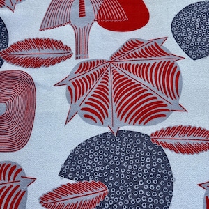 Puede incluir: Una tela blanca con un patrón repetitivo de formas abstractas rojas y grises. Las formas incluyen hojas, círculos y un diseño parecido a un hongo.