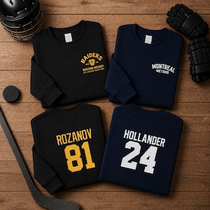May include: Four long-sleeve crewneck sweatshirts in black and navy blue. One black sweatshirt features yellow text reading RAIDERS BOSTON HOCKEY EST. NINETEEN TWENTY-FOUR. One navy sweatshirt says MONTREAL METROS. Others feature names ROZANOV 81 and HOLLANDER 24.