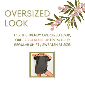 May include: Image promoting an oversized look. Text reads "OVERSIZED LOOK" and "FOR THE TRENDY OVERSIZED LOOK, ORDER 2-3 SIZES UP FROM YOUR REGULAR SHIRT / SWEATSHIRT SIZE." A person is wearing a dark gray oversized t-shirt.