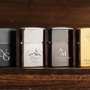 May include: Four personalised lighters in black, silver, and gold. Each lighter features custom engravings, including initials, names, dates, and a geometric design. The lighters are displayed on a wooden surface.