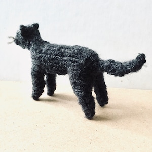 Knitted dark grey cat, bushy tail