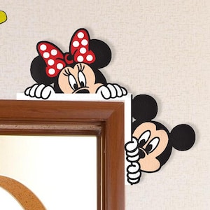 May include: Minnie Mouse and Mickey Mouse wall decals. Minnie wears a red polka dot bow. Mickey peeks around a corner. The word "love" is spelled out with Mickey's hand and yellow letters.