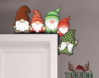 May include: A set of five Christmas gnome decorations with various colored hats and beards. The gnomes are positioned on the top of a white door frame. The gnomes have red, green, and brown hats. The image also includes a "Merry Christmas" sign.