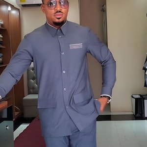 Jeeva Fashions New Stylish Partywear Formal Dark Grey Color Suiting Fabric Designer Safari Suit For Men.