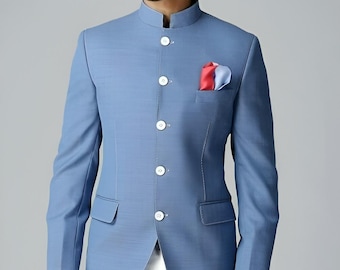 Puede incluir: Chaqueta azul claro con cuello mao, botones blancos y pañuelo de bolsillo con detalles rojos y azules. La chaqueta tiene un corte entallado y se combina con pantalones blancos. Conjunto de ropa formal.