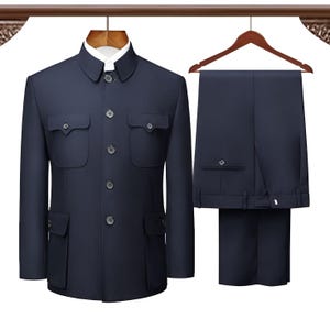 May include: A navy blue suit set, including a jacket and matching trousers, displayed on a hanger. The jacket features a mandarin collar, four front pockets, and button closures. The trousers are pleated and have a button and zipper closure.