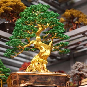 Puede incluir: Una escultura decorativa de árbol bonsái hecha de alambre con un tronco y ramas gruesas y retorcidas de color dorado, adornadas con numerosas cuentas pequeñas de color verde brillante que forman un follaje denso y en capas, en una maceta metálica.
