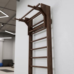 Puede incluir: Una unidad de espaldera de madera de color marr&oacute;n oscuro montada en la pared, que cuenta con una serie de pelda&ntilde;os horizontales y una extensi&oacute;n de barra de dominadas integrada en la parte superior. La estructura consta de paneles laterales.