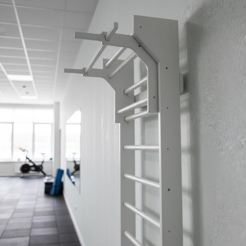 Puede incluir: Una espaldera de gimnasia blanca montada en la pared, que cuenta con una serie de pelda&ntilde;os horizontales y una extensi&oacute;n de barra de dominadas integrada en la parte superior. La estructura est&aacute; fijada verticalmente para ejercicios f&iacute;sicos.