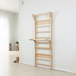 Puede incluir: Una unidad de espaldera de madera de color claro montada en la pared que cuenta con una serie de pelda&ntilde;os horizontales y una plataforma horizontal plegable unida a la secci&oacute;n central, dise&ntilde;ada para ejercicios f&iacute;sicos y escalada.