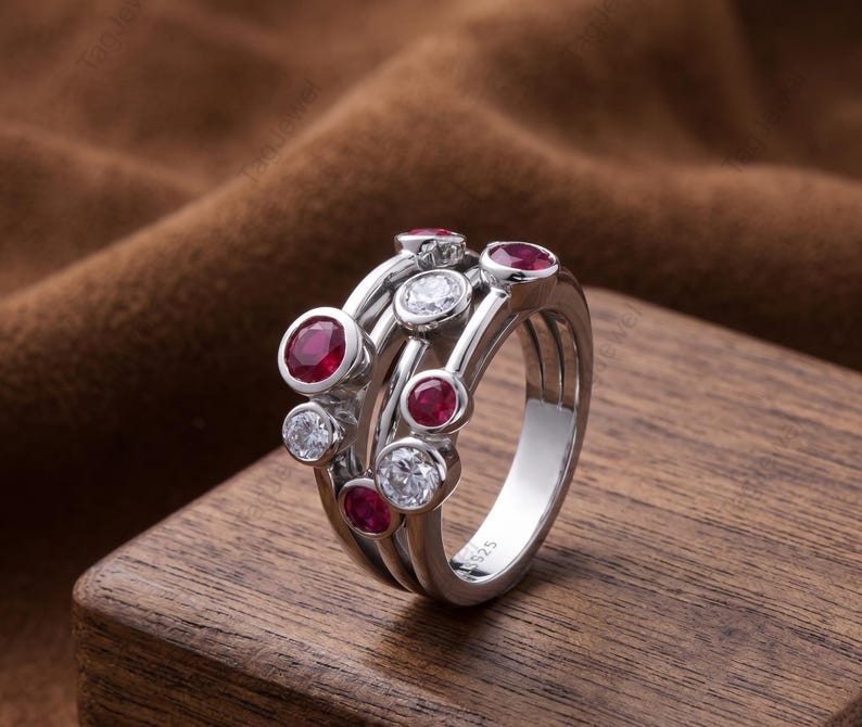 Handcrafted 925 sterling silver cluster ring featuring vibrant round lab-created ruby gemstones and sparkling white accent stones in a modern bubble-inspired bezel setting. This elegant July birthstone statement ring offers contemporary style for everyday wear, anniversaries, birthdays, engagements, Valentine's Day, Mother's Day, and thoughtful gifts for women.