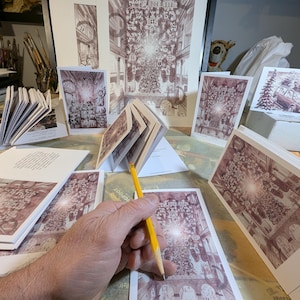 May include: Sepia-toned prints and cards featuring an architectural illustration with a central light source. A hand holds a yellow pencil, poised over a card. The text "12/15 Worcester light show" is visible on the card.