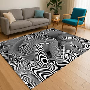 May include: A black and white patterned area rug with a 3D optical illusion design. The rug features curved lines and shapes, creating a visually striking effect. The rug is placed in a living room setting with a grey sofa and blue chair.