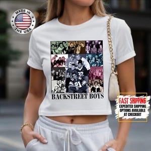 May include: White crop top featuring a collage of images of the Backstreet Boys. The shirt has the text "BACKSTREET BOYS" in black. A "MADE IN THE USA" logo is visible on the top left.