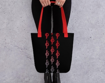 Könnte beinhalten: Eine schwarze Tragetasche mit roten und grauen, sich wiederholenden geometrischen Mustern. Die Tasche hat rote Henkel.