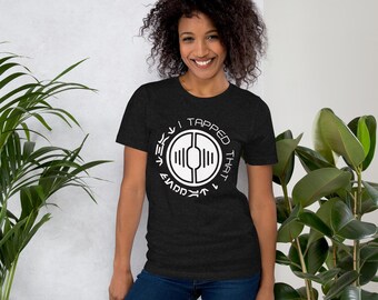 Könnte beinhalten: Dunkelgraues T-Shirt mit einem weißen Grafikdesign, das "I TAPPED THAT" in einem kreisförmigen Design zeigt. Das Design enthält ein stilisiertes Symbol und Text in einer einzigartigen Schriftart. Das Shirt ist kurzärmlig und aus weichem Material.