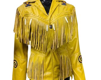 May include: A mustard yellow leather jacket with fringe detailing. The jacket features decorative beading on the shoulders and sleeves, and white accents on the fringe. The jacket has a button closure and a collared neckline.