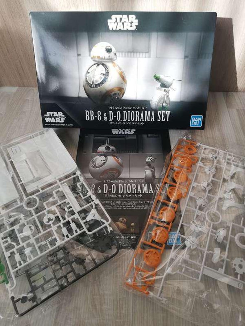 May include: A Star Wars BB-8 & D-O Diorama Set model kit. The box features images of the BB-8 and D-O droids. The kit includes plastic model parts in clear and orange sprues, ready for assembly. The box has the Star Wars logo.