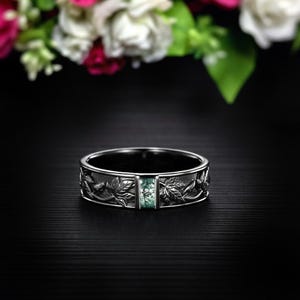 Puede incluir: Una taza de cerámica blanca con un asa negra y el texto "But First, Coffee" en un estilo manuscrito. La taza está sobre una superficie blanca. La taza mide aproximadamente 10 cm de alto.