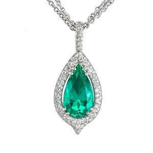 May include: A teardrop-shaped pendant necklace featuring a vibrant green gemstone surrounded by a halo of small, sparkling diamonds. The pendant hangs from a delicate silver chain, creating an elegant and eye-catching piece of jewelry.