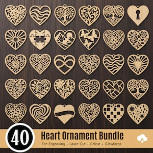 Op de afbeelding: Een verzameling van 40 houten hartornamenten met diverse uitgesneden ontwerpen, waaronder bloemen, bomen en geometrische patronen. De ornamenten zijn gerangschikt op een donkerhouten oppervlak. De tekst "Heart Ornament Bundle" is zichtbaar.