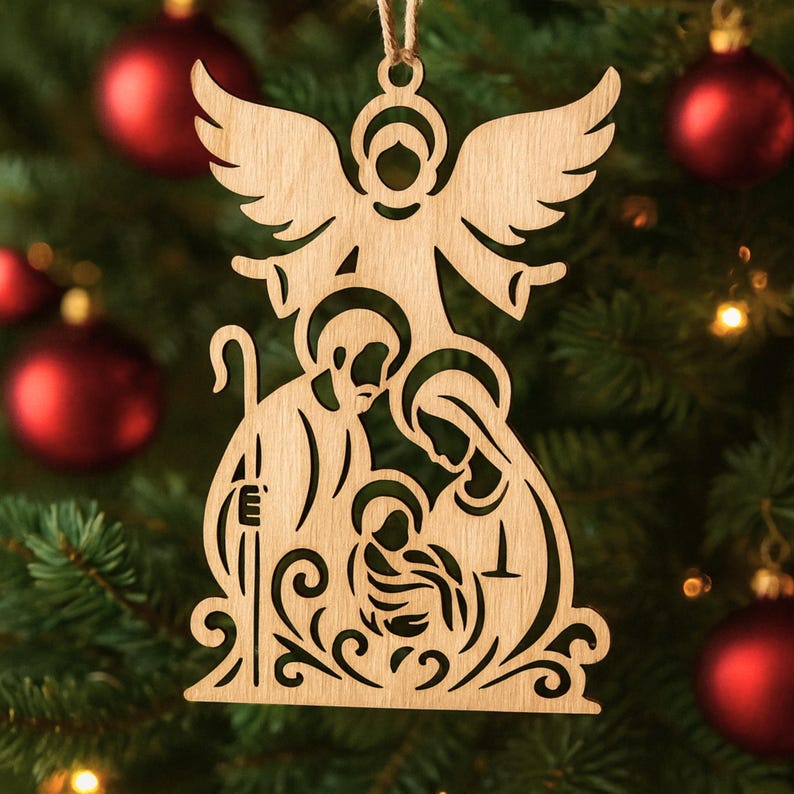 May include: Wooden Christmas ornament depicting the Nativity scene, with an angel at the top. The ornament shows Mary, Joseph, and baby Jesus, with decorative scrollwork at the base. It is suspended from a natural twine string.