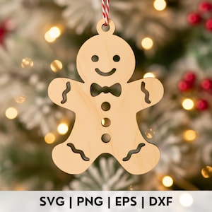 Könnte beinhalten: Ein Weihnachtsornament in Form eines Lebkuchenmanns aus Holz mit einem lächelnden Gesicht, einer Fliege und dekorativen Details. Das Ornament hängt an einer rot-weiß gestreiften Schnur. Am unteren Rand des Bildes steht der Text "SVG | PNG | EPS | DXX".