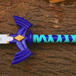 Pu&ograve; includere: Una spada giocattolo con lama argentata decorata da un emblema triangolare nero, una guardia blu scuro con un diamante dorato centrale e un'impugnatura avvolta da un nastro turchese brillante. Il pomolo e la guardia sono in plastica blu lucida.
