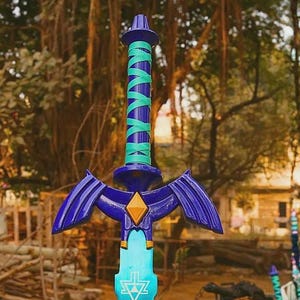 Pu&ograve; includere: Una spada giocattolo con elsa blu scuro e impugnatura avvolta in turchese brillante, una guardia blu scuro con un emblema centrale giallo a forma di diamante e una lama azzurra contrassegnata da un simbolo triangolare bianco vicino alla guardia.