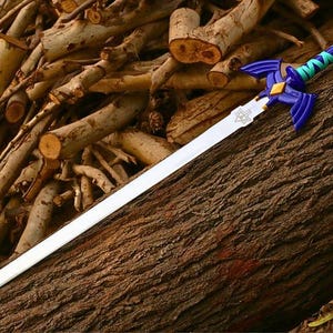 Pu&ograve; includere: Una replica di spada con lama color argento e un emblema triangolare vicino all'elsa. L'elsa &egrave; blu scuro con guardie a forma di ali, un diamante dorato centrale e un'impugnatura avvolta da fasce alternate color ottanio e blu.