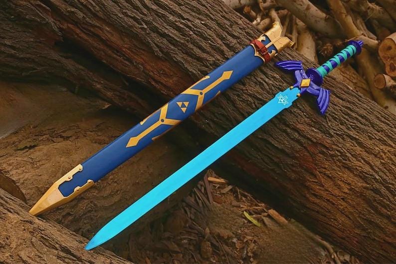 Pu&ograve; includere: Una spada blu brillante con una guardia viola dotata di estensioni a forma di ala e un'impugnatura avvolta in verde acqua e viola. Il fodero blu abbinato presenta accenti geometrici dorati e un emblema triangolare dorato nella parte alta.