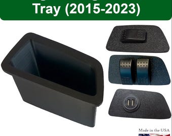May include: Black Dodge Charger Shifter Tray (2015-2023). The image shows a black tray with a rectangular shape and a deep interior. Additional components include a black button, two pedals, and a USB port. Made in the USA.