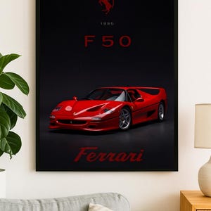 May include: Framed poster featuring a red Ferrari F50 sports car. The poster has a black background with the text "1995 F50" and the Ferrari logo. The word "Ferrari" is written at the bottom.