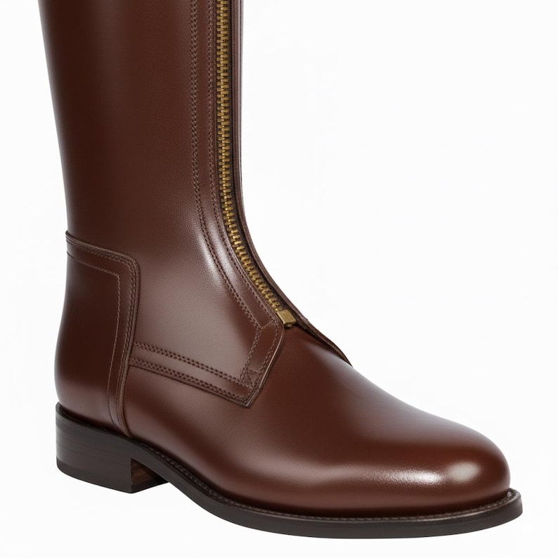 May include: A brown leather riding boot with a full-length brass zipper. The boot has a smooth, polished finish and a low heel. The design is sleek and classic, suitable for equestrian activities or fashion.