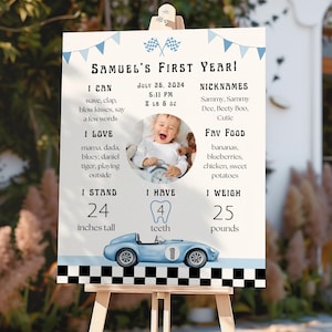 May include: A personalized sign for a first birthday, featuring a photo and details like height (24 inches), weight (25 pounds), and favorite foods. The design includes a blue race car and checkered flag accents, with the text "Samuel's First Year!"