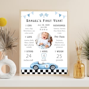May include: A framed print celebrating a baby's first year, featuring a photo, stats, and a blue race car illustration. The text includes "Samuel's First Year!" and details like height (24 inches) and weight (25 pounds).