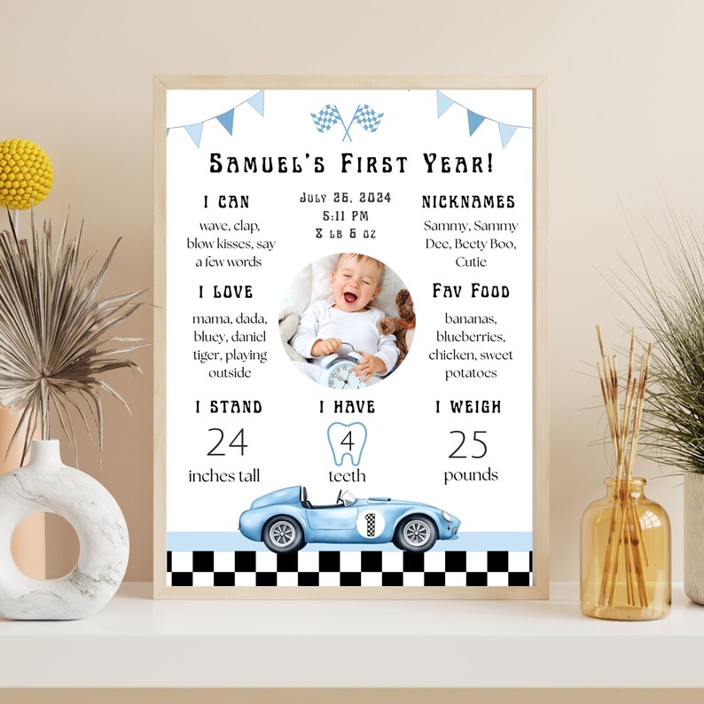 May include: A framed print celebrating a baby's first year, featuring a photo, stats, and a blue race car illustration. The text includes "Samuel's First Year!" and details like height (24 inches) and weight (25 pounds).