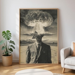 Puede incluir: Una impresión en blanco y negro enmarcada representa a un hombre con traje con una explosión de nube en forma de hongo reemplazando su cabeza. La obra de arte tiene una estética vintage, con una carretera y un paisaje de fondo. La impresión está en un marco de madera.