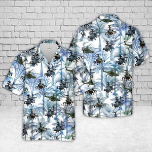 May include: White short-sleeve button-down shirt with a tropical pattern of blue palm trees and military helicopters. The shirt has a classic collar and a relaxed fit, perfect for casual wear.
