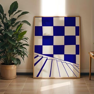Könnte beinhalten: Ein gerahmter Kunstdruck mit einem blau-weißen Schachbrettmuster und einem Treppenmotiv. Das Kunstwerk befindet sich in einem Raum mit einer großen Topfpflanze und einem kleinen Beistelltisch aus Holz.